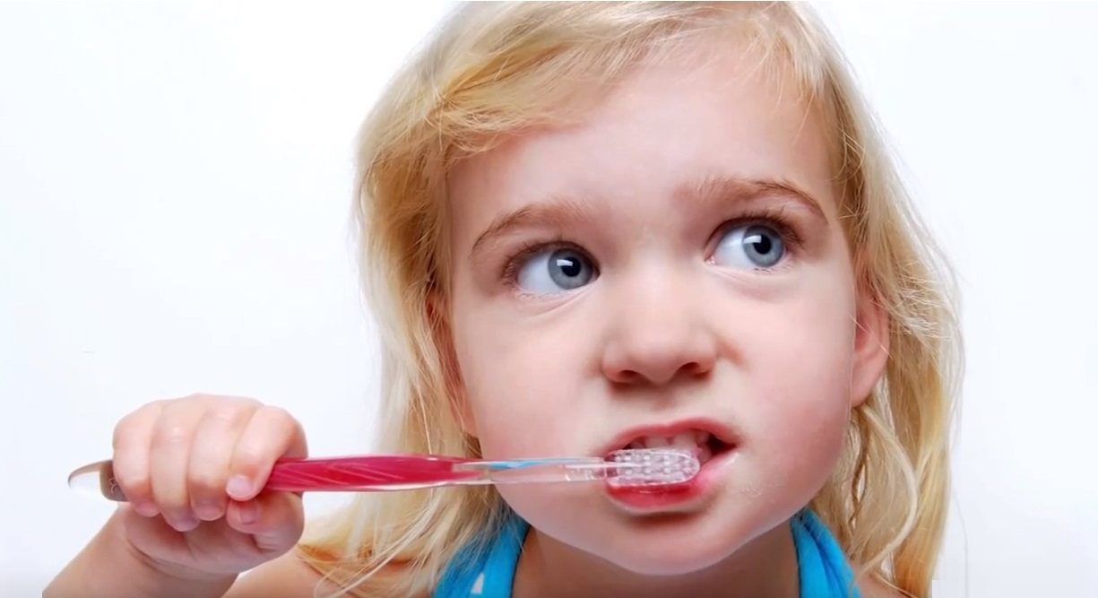 child brushing teeth blue eyes toothbrush