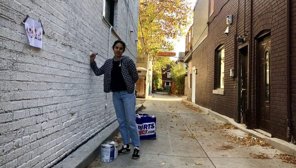 Toronto Mural Artist, Vesna Asanovic latex paints artwork in Toronto alley