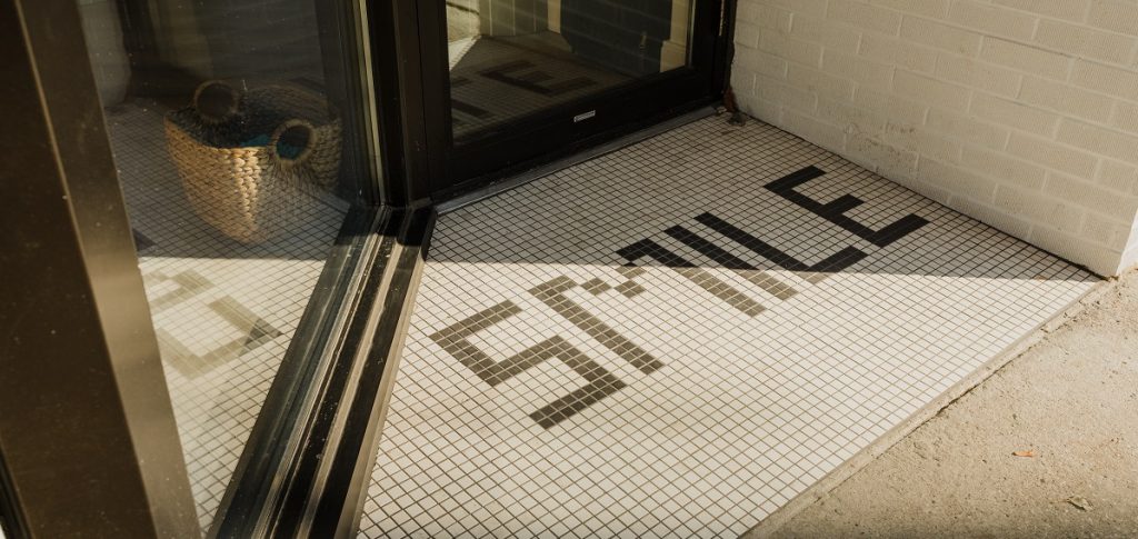 front entrance mosaic tile spelling out the word smile at dental office 